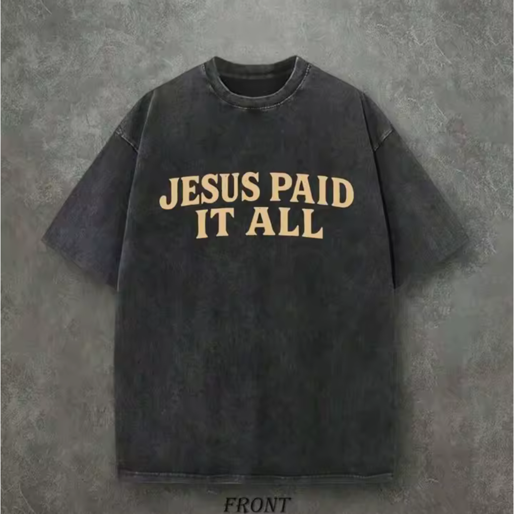 Black t-shirt with 'Jesus Paid It All' text on a gray background